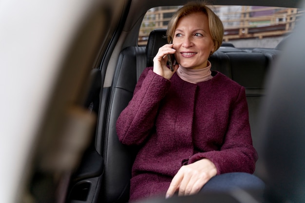 Elegante mujer madura sentada en un taxi