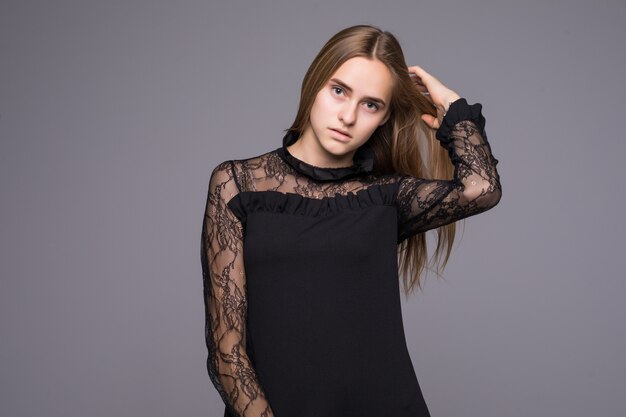 Elegante mujer de moda en vestido negro de la mano en el cabello