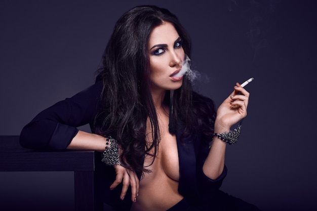 Elegante mujer morena caliente fumando un cigarrillo