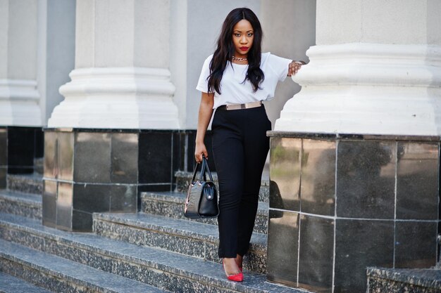 Elegante mujer de negocios afroamericana en las calles de la ciudad