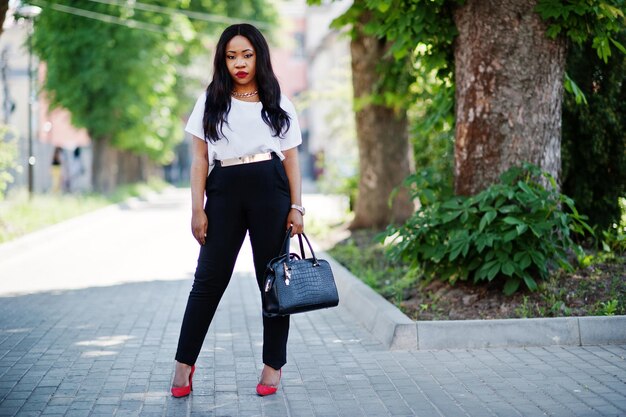 Elegante mujer de negocios afroamericana en las calles de la ciudad