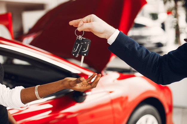 Elegante mujer negra en un salón de autos.