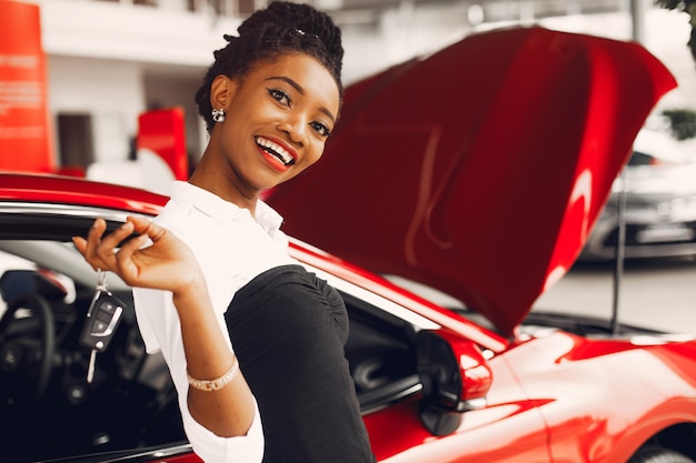 Elegante mujer negra en un salón de autos.