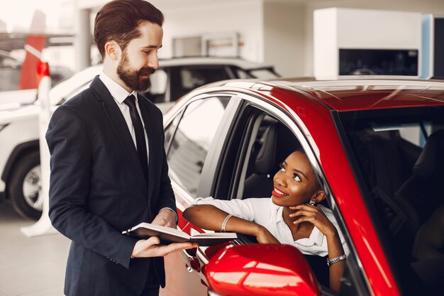 Elegante mujer negra en un salón de autos.