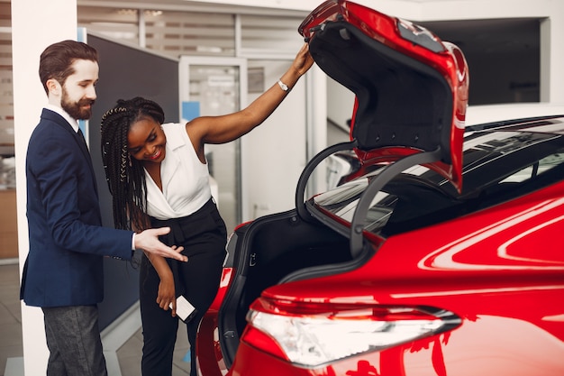 Elegante mujer negra en un salón de autos.