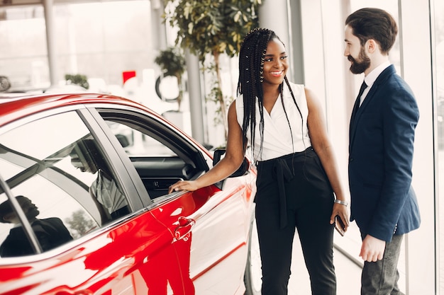 Elegante mujer negra en un salón de autos.