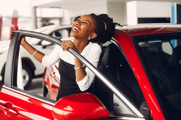 Elegante mujer negra en un salón de autos.