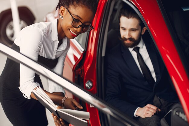 Elegante mujer negra en un salón de autos.