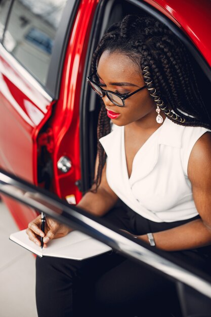 Elegante mujer negra en un salón de autos.