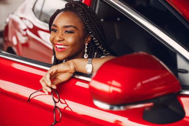 Elegante mujer negra en un salón de autos.