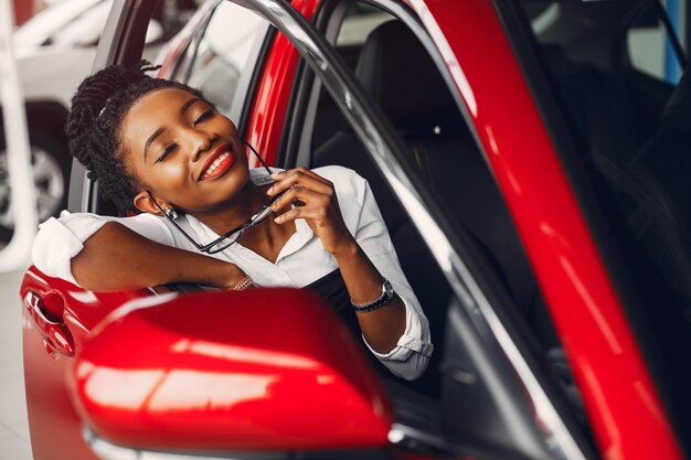 Elegante mujer negra en un salón de autos.