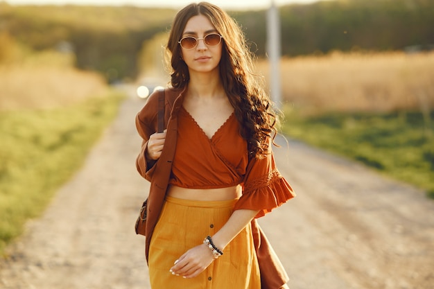 Elegante mujer pasar tiempo en un campo de verano