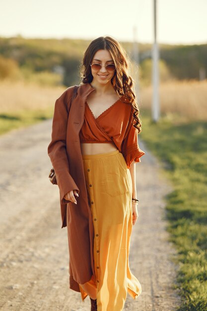 Elegante mujer pasar tiempo en un campo de verano