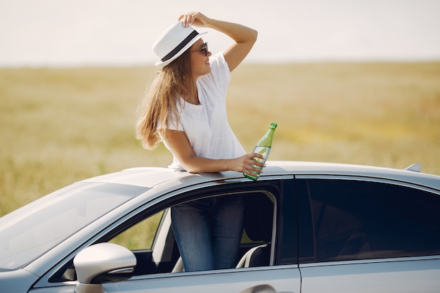 Foto gratuita elegante mujer de pie bin una escotilla del coche