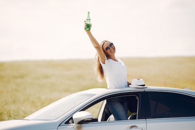 Elegante mujer de pie bin una escotilla del coche