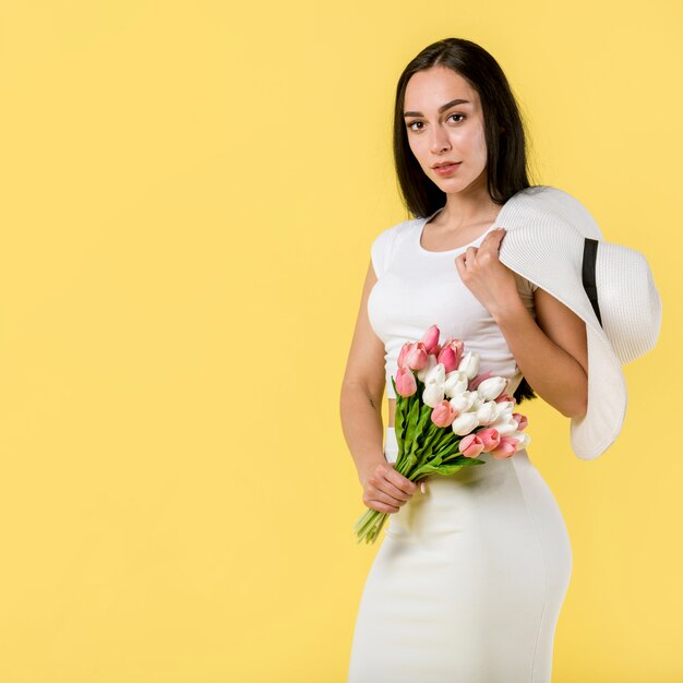 Elegante mujer de pie con flores.