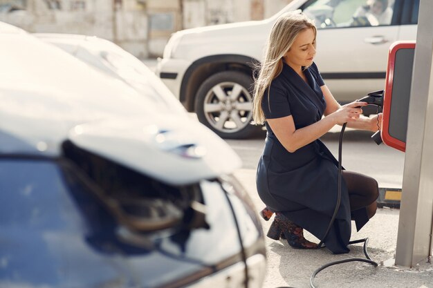 Elegante mujer de pie en una gasolinera