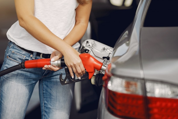 Foto gratuita elegante mujer de pie en una gasolinera