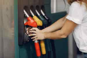 Foto gratuita elegante mujer de pie en una gasolinera