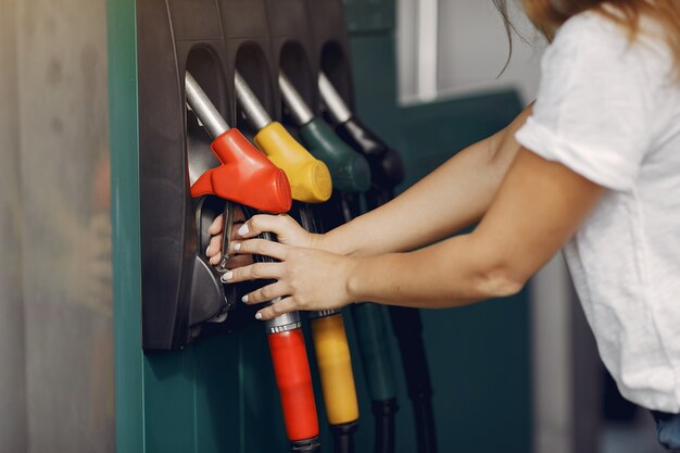 Elegante mujer de pie en una gasolinera