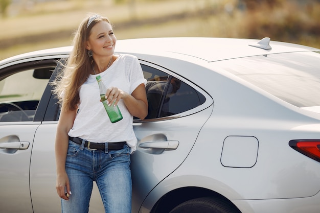 Elegante mujer de pie junto al auto