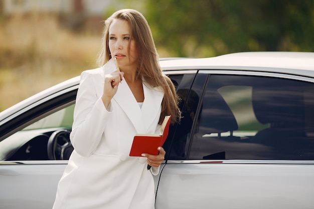 Elegante mujer de pie junto al auto