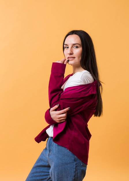 Elegante mujer posando con un fondo naranja