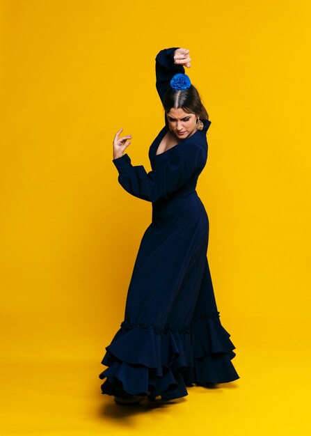 Elegante mujer realizando floreo con fondo naranja