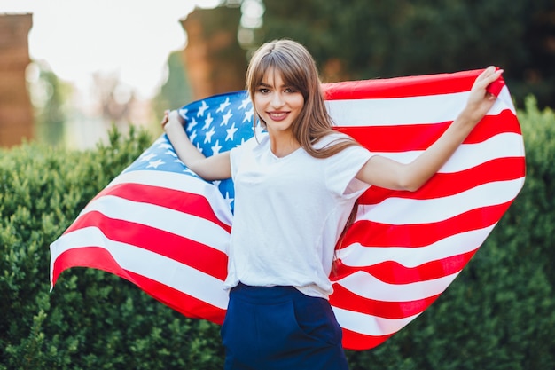 Elegante mujer rubia con gafas de sol y una camisa blanca con estilo casyal