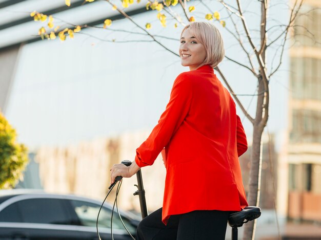 Elegante mujer rubia posando con su bicicleta