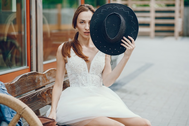 Foto gratuita elegante mujer sentada en un banco