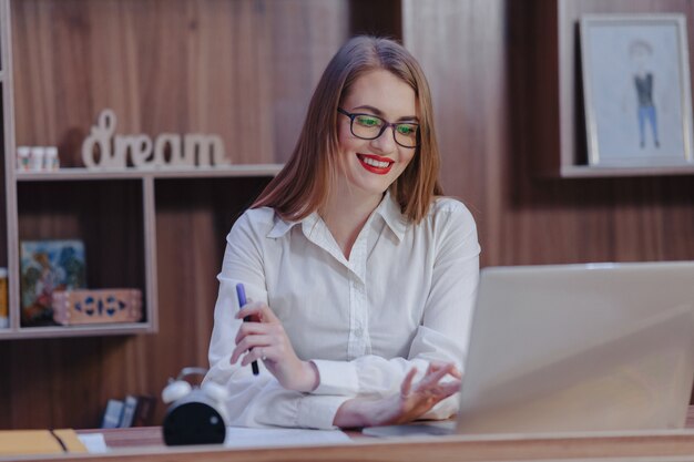Elegante mujer trabaja en un escritorio portátil en una oficina moderna