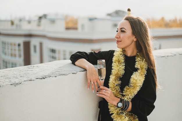 Elegante mujer vestida de negro con una copa de champán