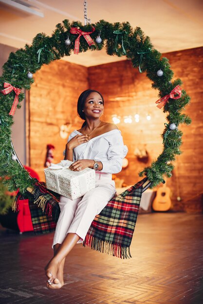 Elegante niña negra en las decoraciones navideñas