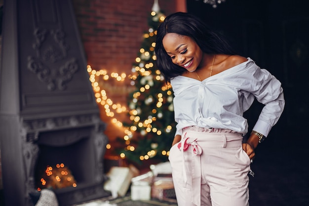 Elegante niña negra en las decoraciones navideñas