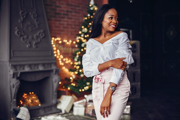 Elegante niña negra en las decoraciones navideñas