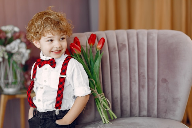 Elegante niño lindo con ramo de tulipán