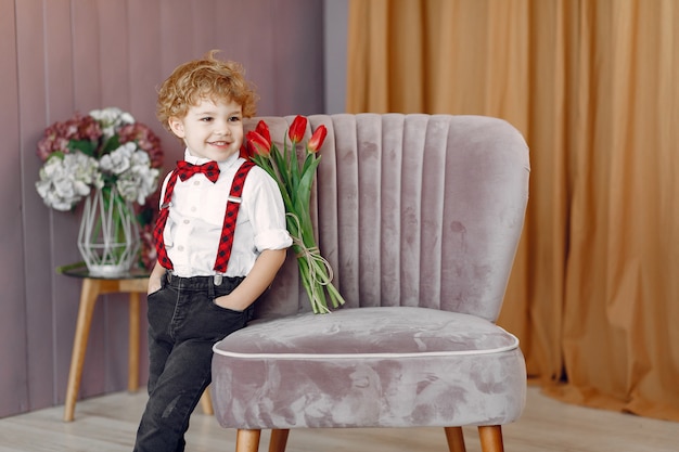 Elegante niño lindo con ramo de tulipán