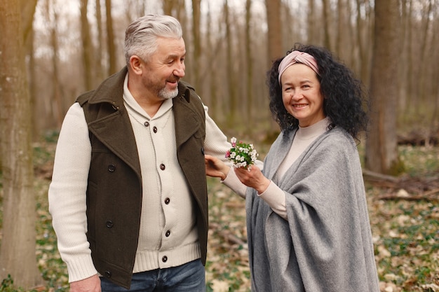 Elegante pareja adulta en un bosque de primavera