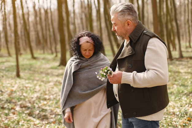 Elegante pareja adulta en un bosque de primavera