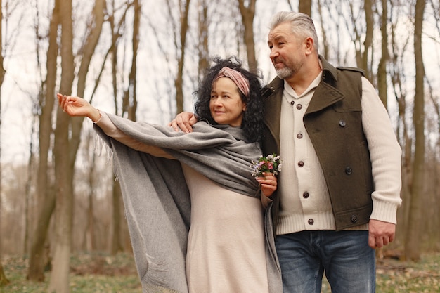 Elegante pareja adulta en un bosque de primavera