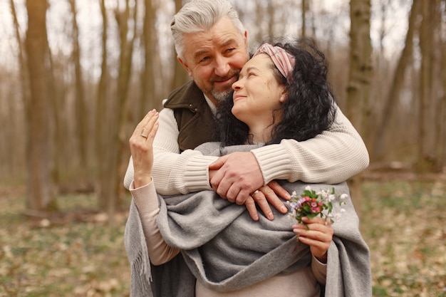 Elegante pareja adulta en un bosque de primavera