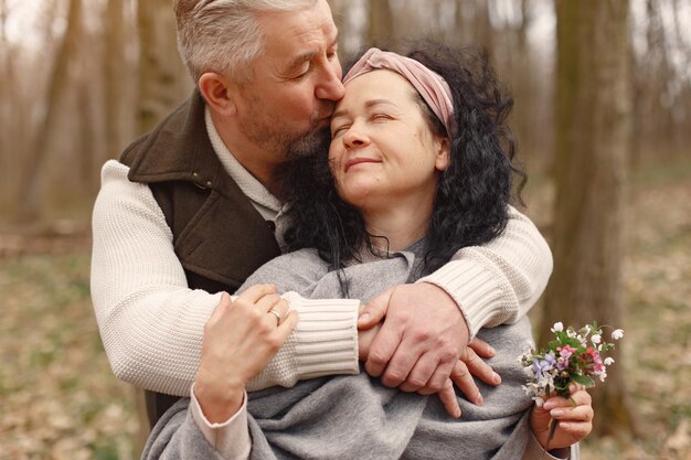 Elegante pareja adulta en un bosque de primavera