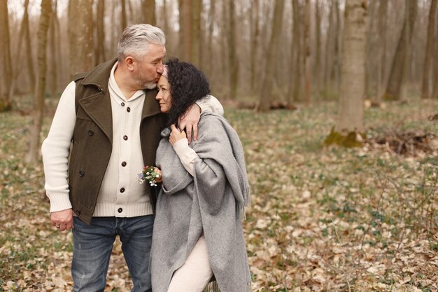 Elegante pareja adulta en un bosque de primavera