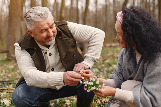 Elegante pareja adulta en un bosque de primavera