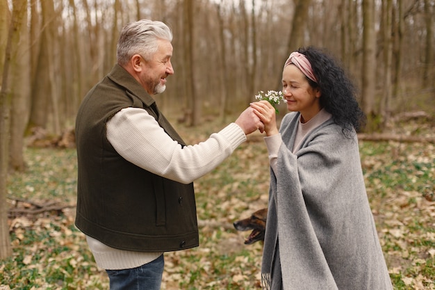 Elegante pareja adulta en un bosque de primavera