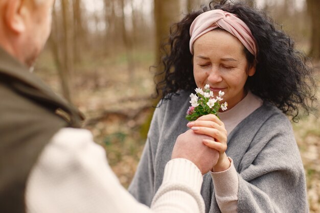 Elegante pareja adulta en un bosque de primavera