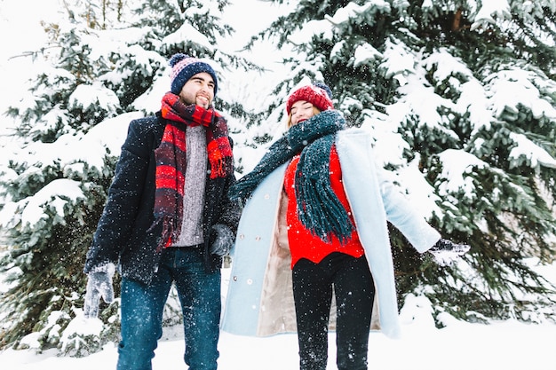 Elegante pareja amorosa en el bosque de invierno