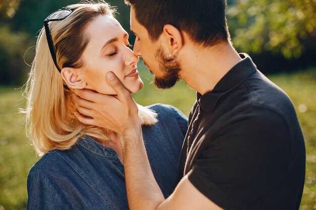 Elegante pareja amorosa de pie en un parque.