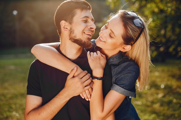 Elegante pareja amorosa de pie en un parque.